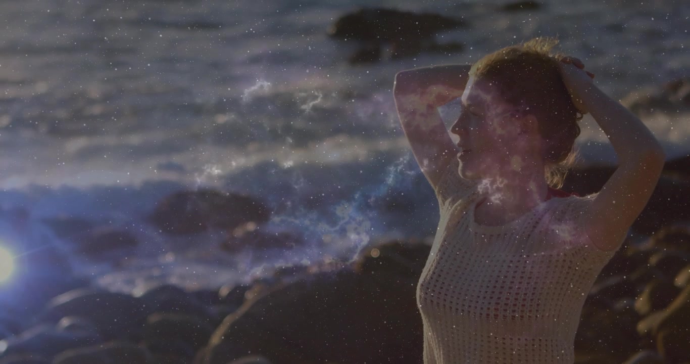 Mulher em Pé na Praia ao Pôr do Sol com Efeito de Sobreposição Cósmica