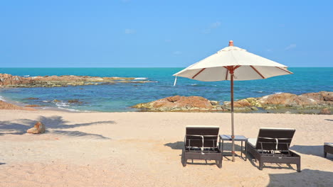 Sun-umbrella-and-deckchair-on-rocky-beach-with-sea-in-background