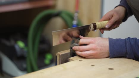 luthier marking slots for attaching starting point of strings on fretboard on newly built electric resonator guitar