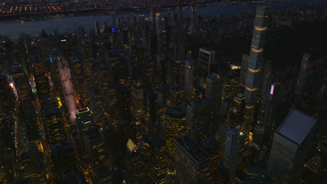 High-angle-view-of-modern-tall-buildings-in-midtown.-Evening-in-city.-Tilt-down-to-streets-between-built-up-blocks.-Manhattan,-New-York-City,-USA