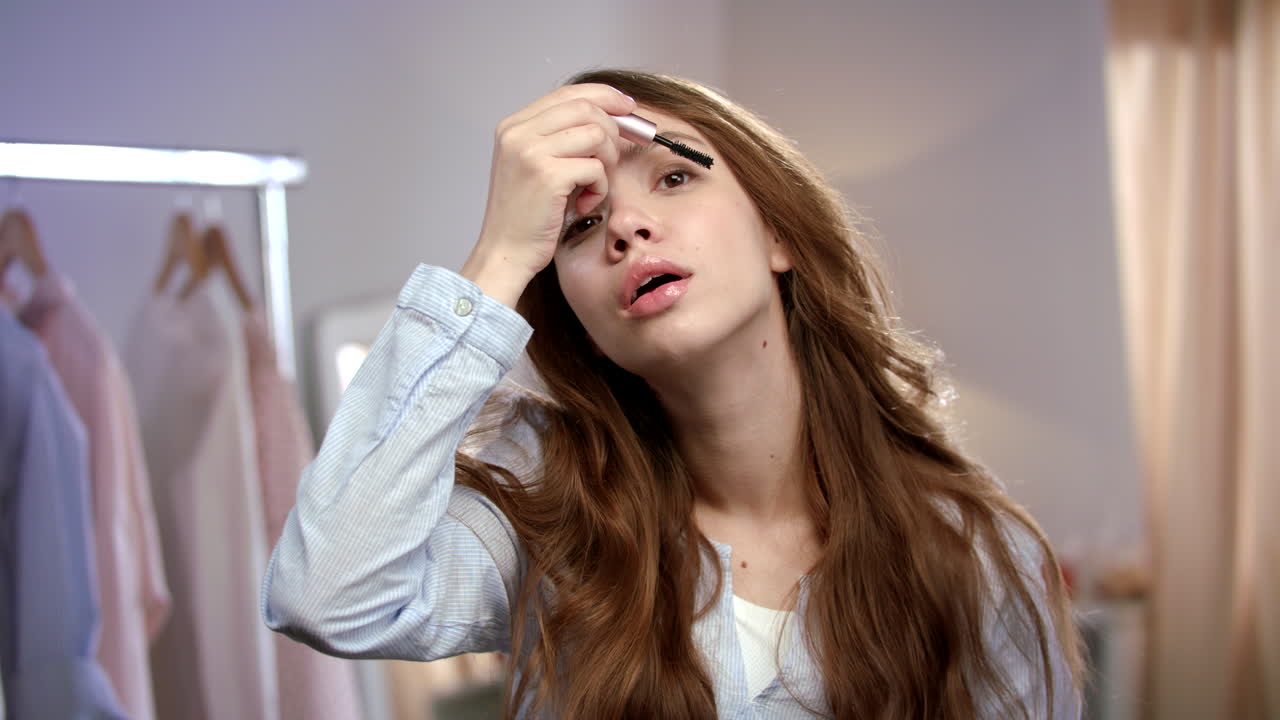 마스카라를 적용하는 젊은 여성. 아침에 메이크업을 적용하는 아름다움 여성