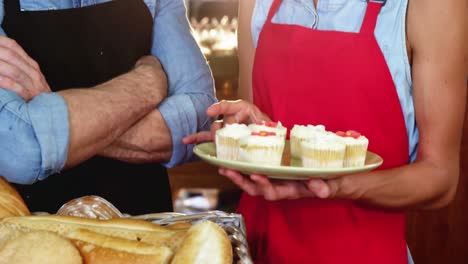 Smiling-staff-interacting-at-bakery-counter