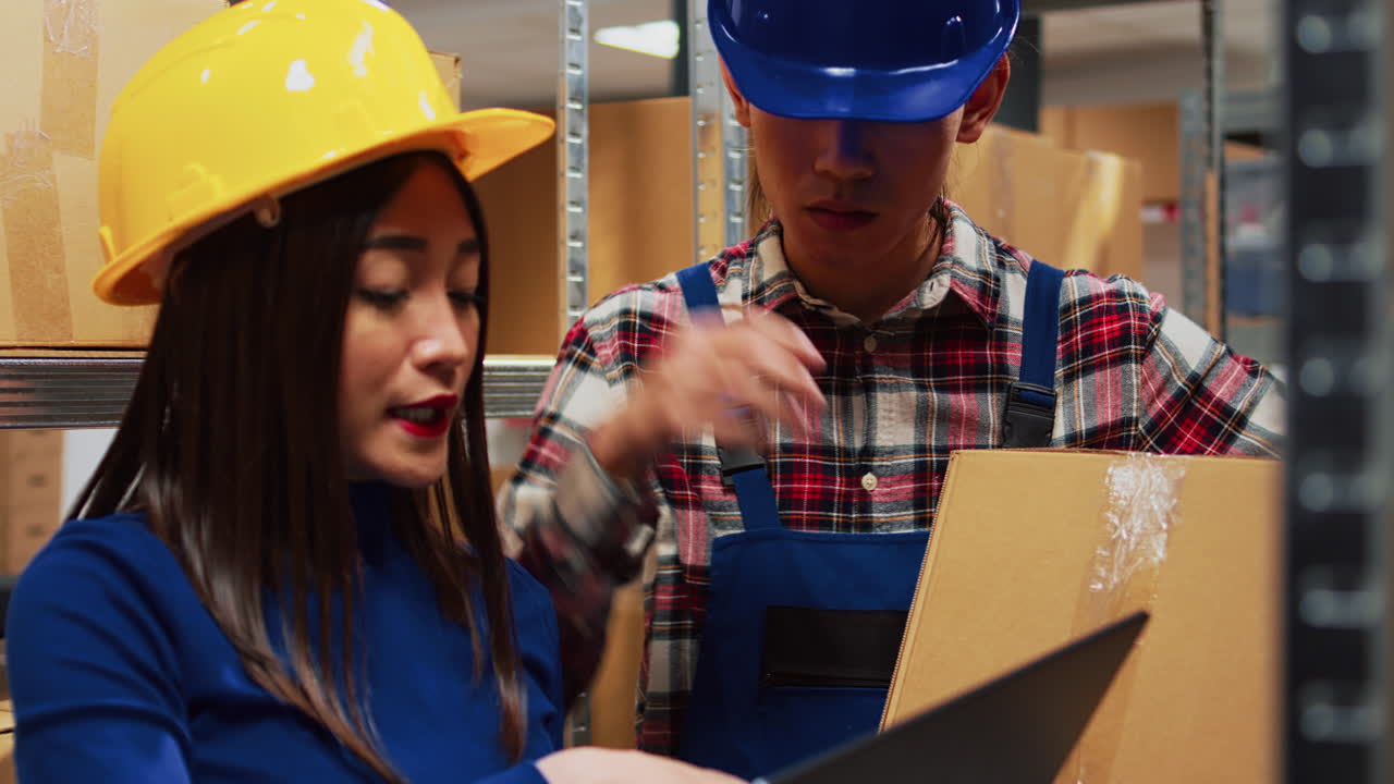 Warehouse workers checking inventory on a laptop