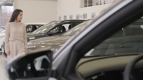 woman choosing a car in a car showroom