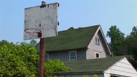 an old basketball hoop near a house