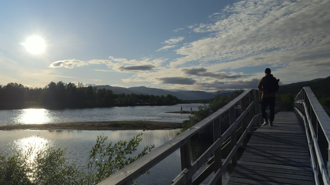 스웨덴의 황야에서 다리를 걷고 있는 가을 행복한 등산객 남자