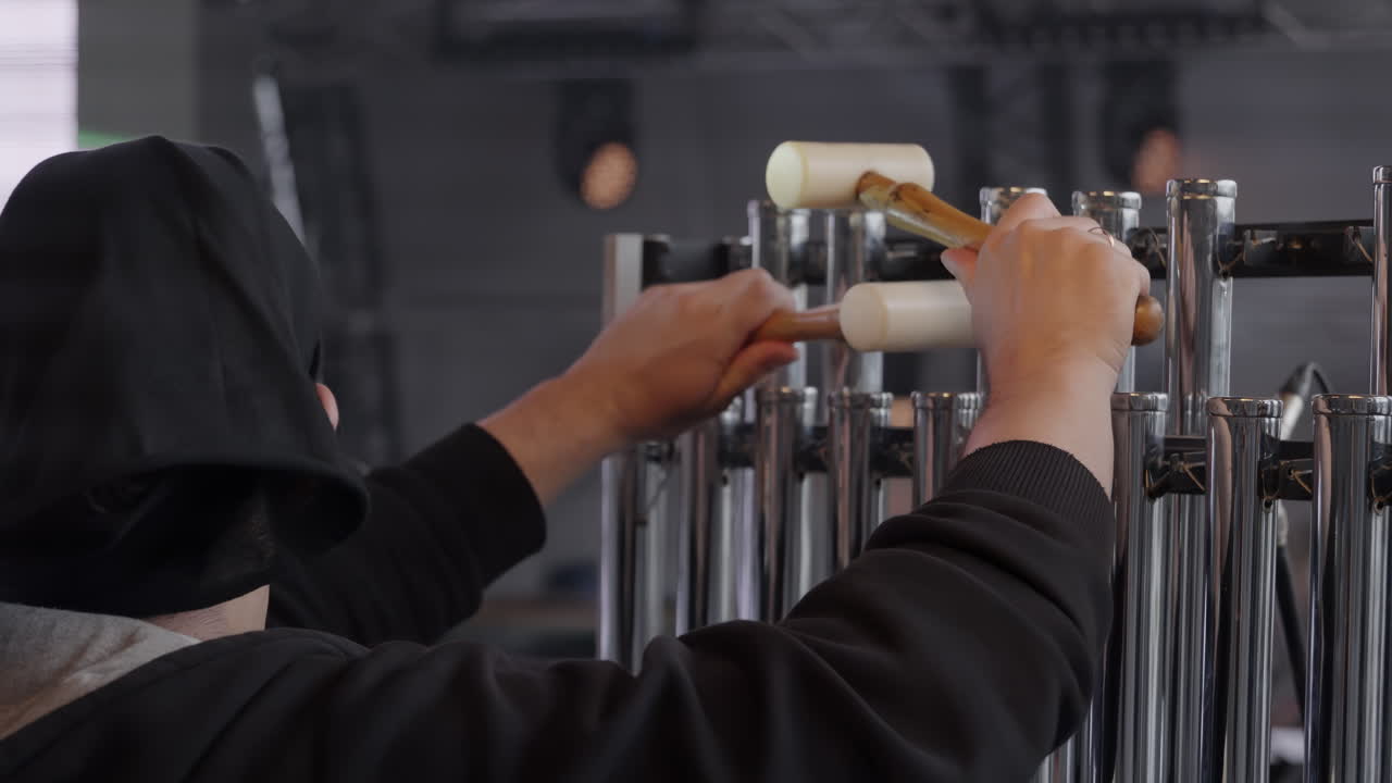 튜브 모양의 종을 연주하는 사람