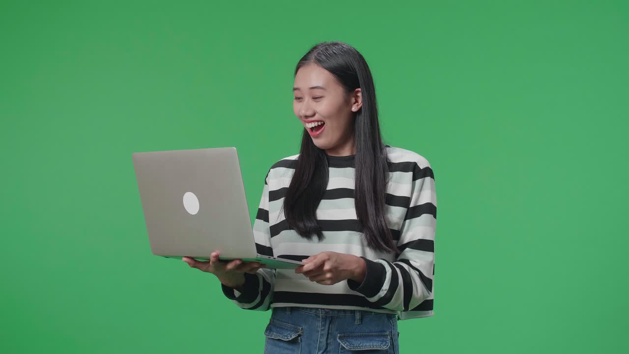 Woman Excitedly Looking at Laptop