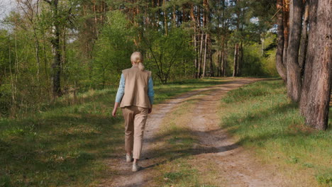 mujer caminando por un camino del bosque