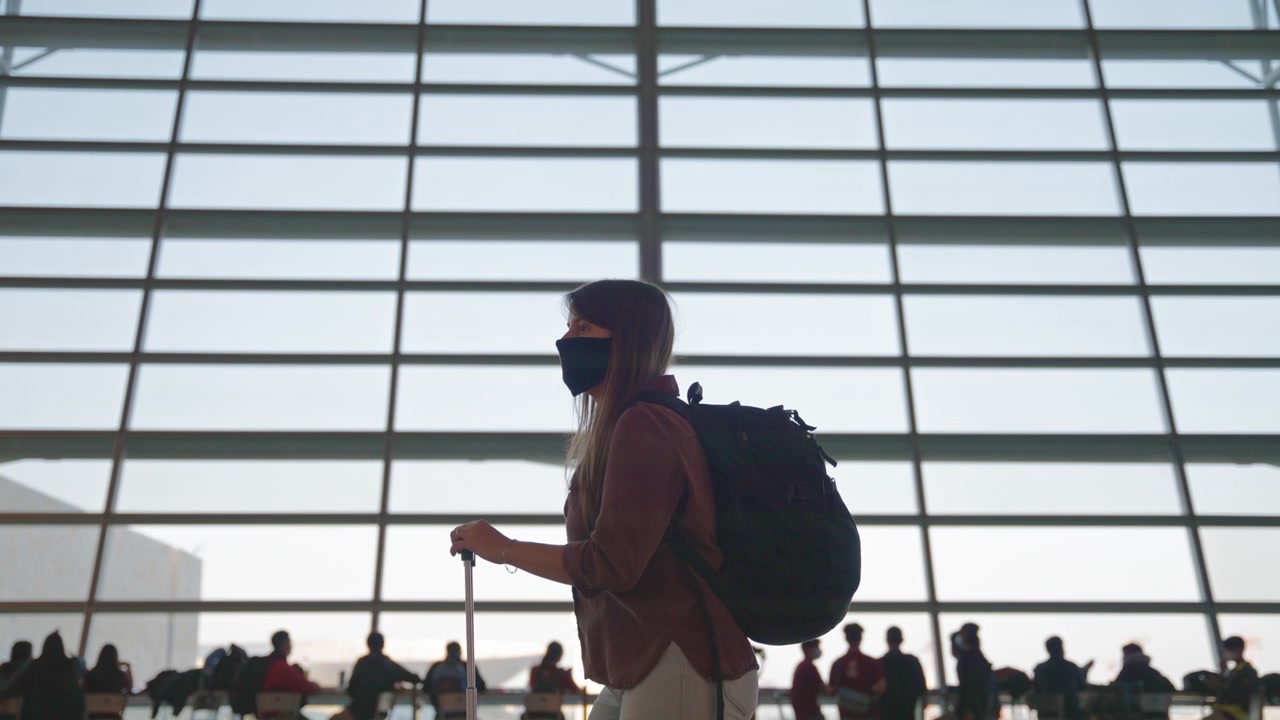 Woman in mask waiting for the flight