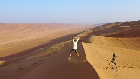 Un-Hombre-Tomando-Una-Foto-Con-Disparador-Automático-Solo-En-El-Desierto,-Omán