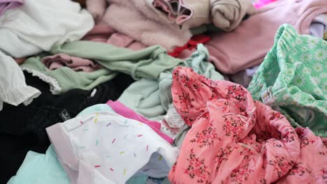 woman organizing a pile of children's clothes