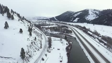 Antenne---Kamerawagen-über-Fluss-Und-Autobahn-Während-Eines-Schneesturms