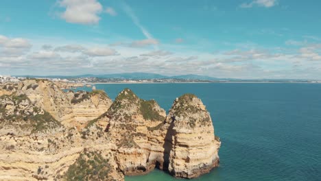 Lagos-southern-tip-coastline-bordered-by-Algarve-idyllic-Sea,-Portugal---Aerial-ascending-rocket-reveal-shot