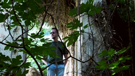 man exploring abandoned building in a green garden