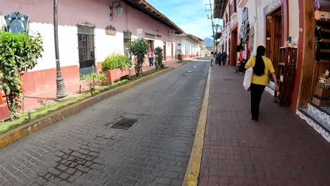 exploring a bustling colonial street with shops and locals in mexico