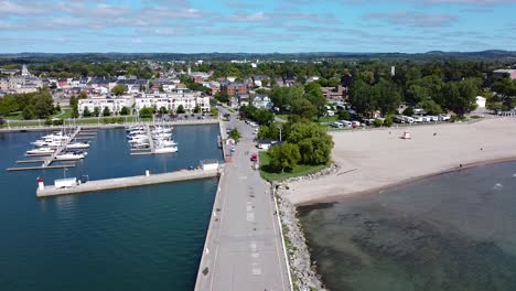 historic waterfront tourist town with pier, sandy beach and marina with yachts and sail boats docked