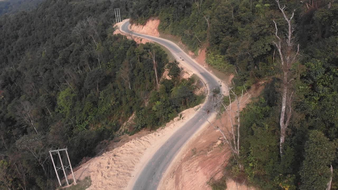 pequeño camino entre las montañas en laos con conducción de motocicleta, aéreo