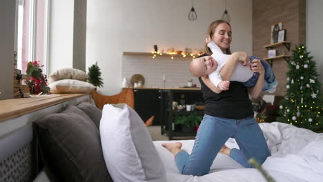 portrait of happy laughing baby hugging with cheerful young smiling mother. scene of pure love and happiness. family, motherhood and lifestyle concept.