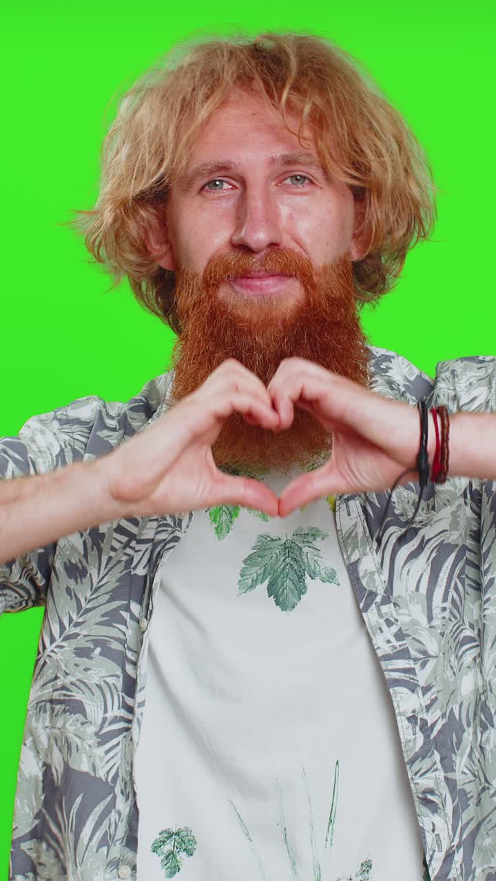 hombre guapo sonriente hace un gesto de corazón demuestra un signo de amor expresa buenos sentimientos y simpatía