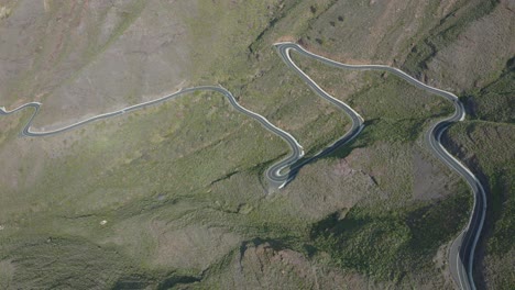 Drone-shot-of-a-curved-road-with-cars-in-the-mountain
