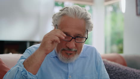 mature man putting on eyeglasses