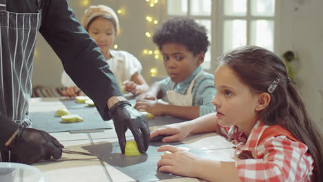 girl helping chef with cutting fruit on culinary masterclass