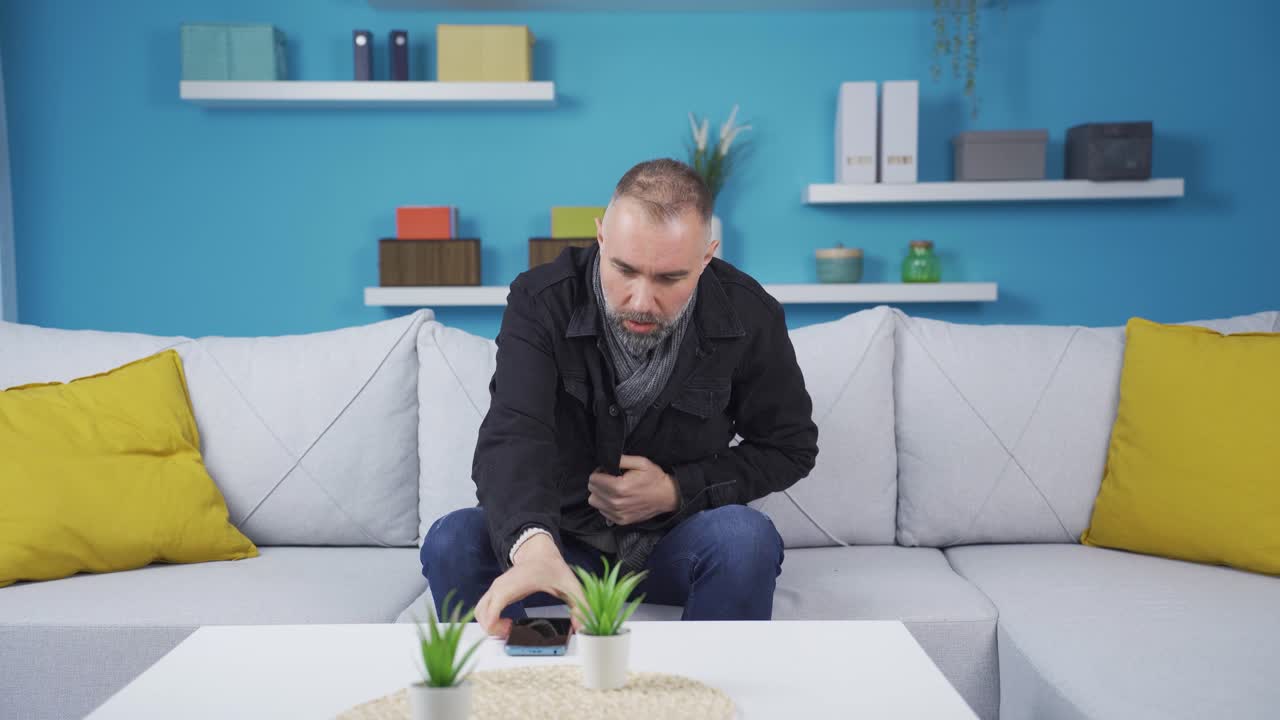 The man who is cold at home. He's making a phone call.