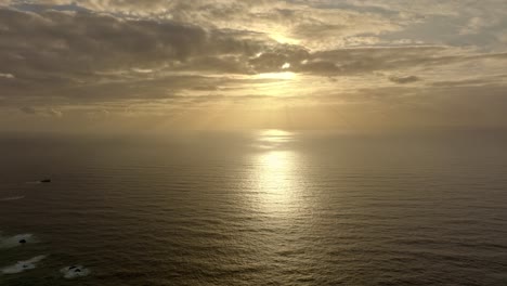 Aerial-Cinematic-Shot-Flying-the-pacific-ocean,-Coastline-Of-Chiloe-Island-With-Golden-Sunset-On-The-Horizon