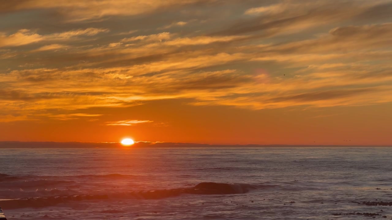 Solnedgang over havet nær Cape Town, Sydafrika.