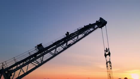 a silhouetted crane against a vibrant sunset sky, symbolizing construction and engineering at dusk, capturing the beauty of industrial processes and nature's palette