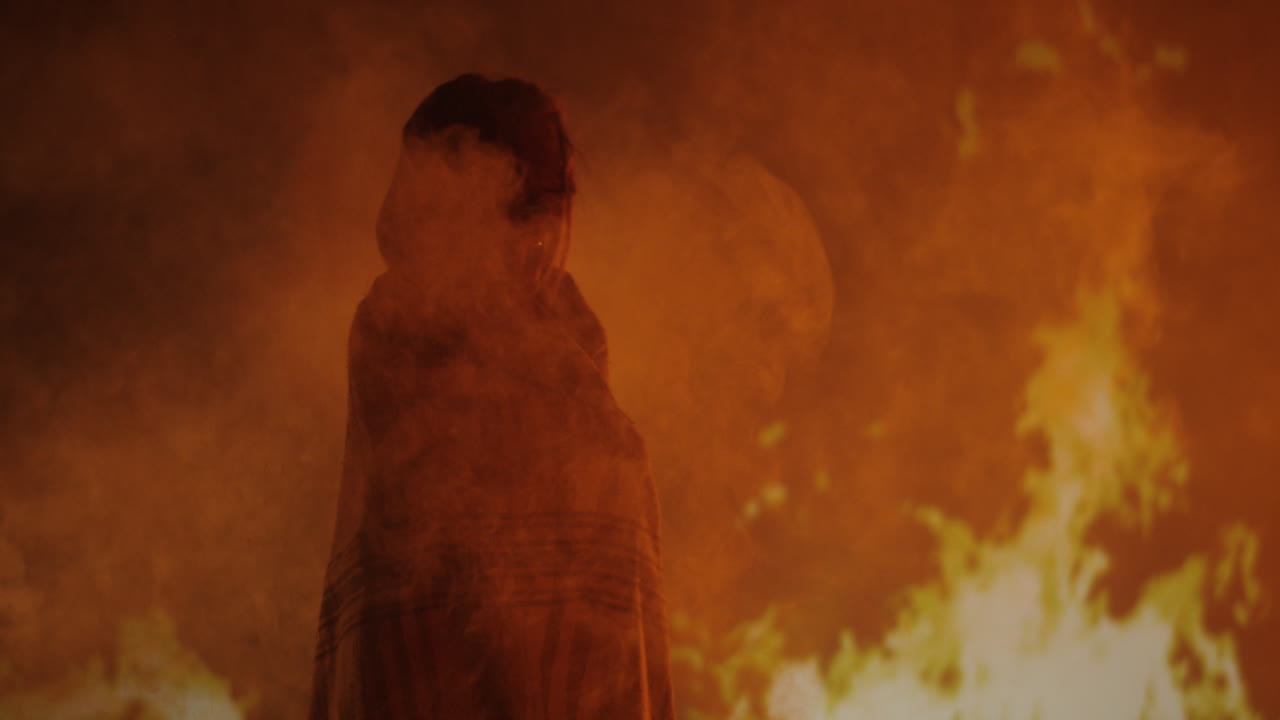 Person Standing Before a Fiery Inferno