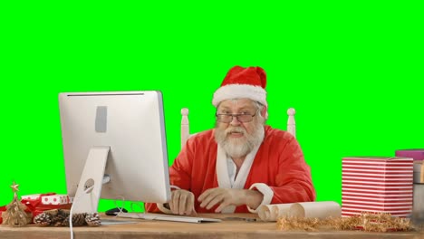 Santa-claus-talking-while-working-on-personal-computer