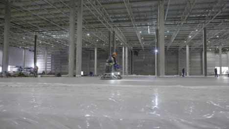 construction workers pouring concrete floor in a warehouse