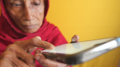 Mano-De-Mujer-Mayor-Usando-Teléfono-Inteligente-De-Cerca