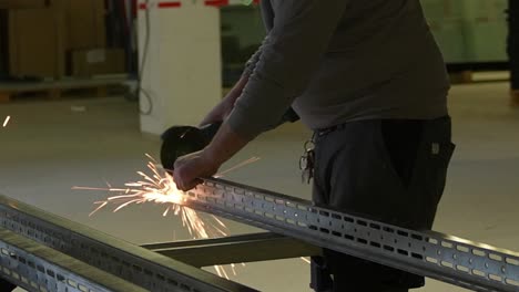 worker man cuts industry steel beams using cutting disc angle grinder