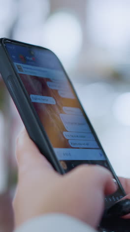 primer plano de alguien escribiendo a mano o hablando en un teléfono inteligente con un fondo suave y borroso con luces bokeh, capturando un momento de comunicación digital en un entorno moderno y relajado
