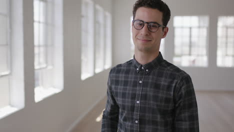 portrait-of-attractive-young-hipster-man-wearing-glasses-smiling-confident-enjoying-successful-lifestyle-move-independent-male-in-new-apartment
