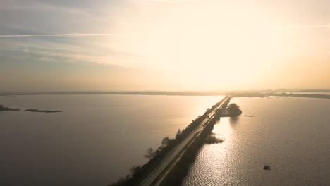 sunrise over a road bridge over a lake