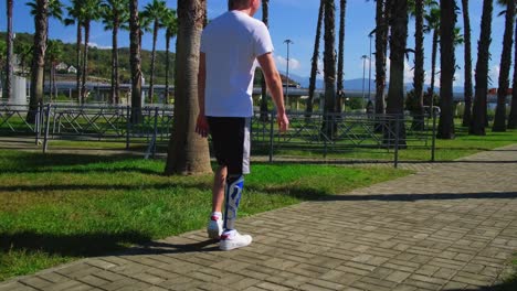 man with prosthetic leg walking in a park