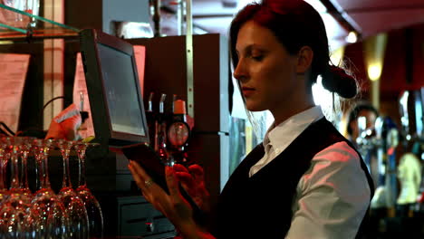 smiling barkeeper using digital tablet