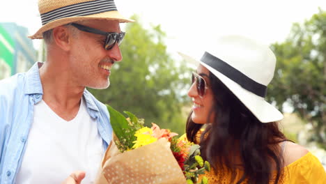 Pareja-Sonriente-Con-Flores