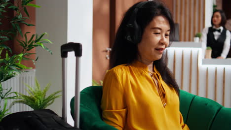 hotel guest using laptop with headset in lounge area