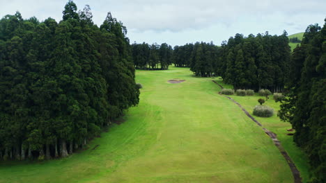 Toma-Aérea-Cinematográfica-De-Un-Campo-De-Golf-Verde-Con-Un-Dron