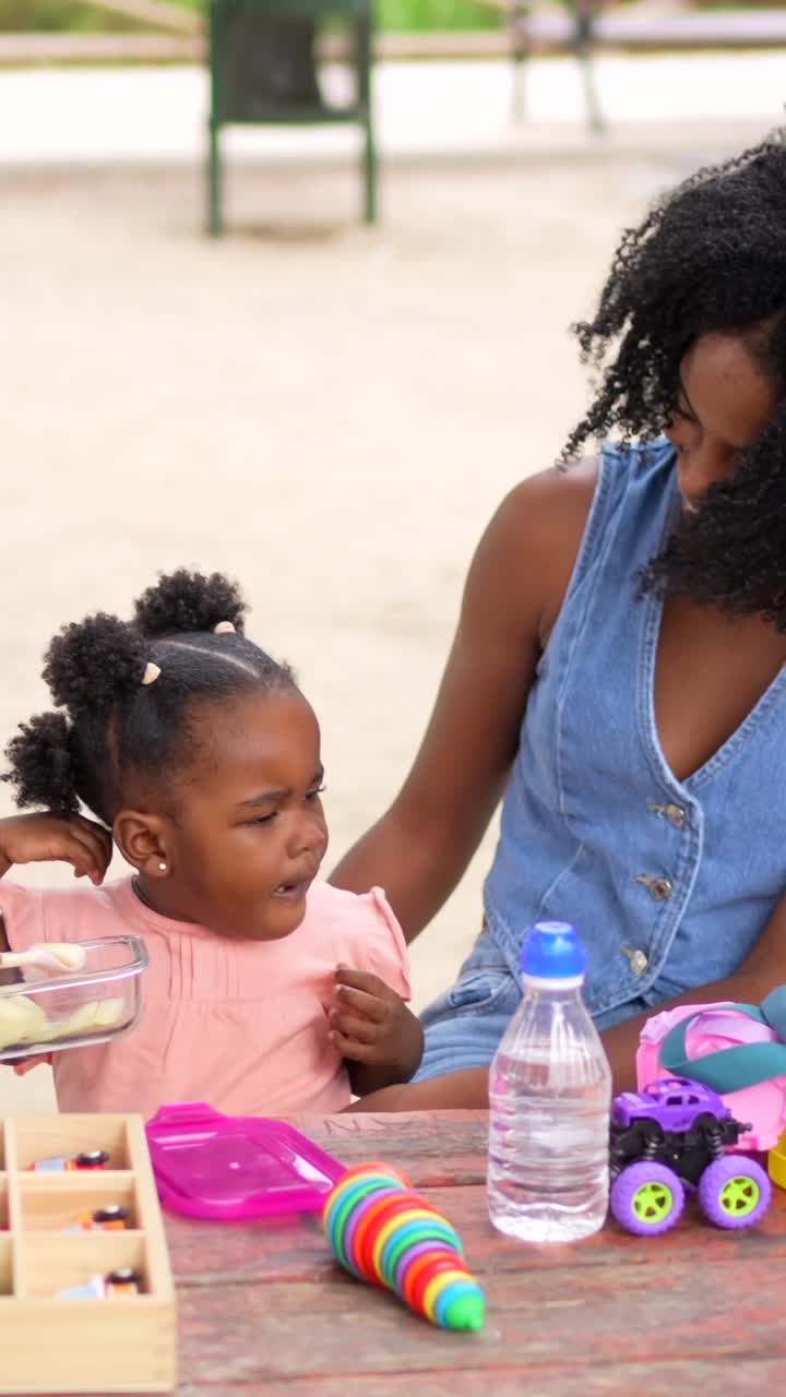 Child being fed food outdoors
