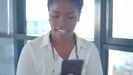 Cheerful-focused-African-American-office-worker-texting-message