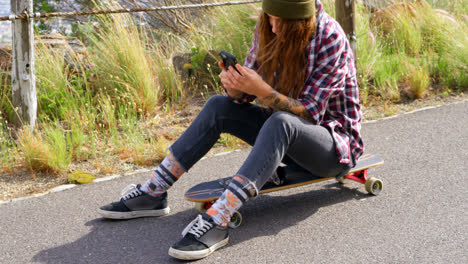 Side-view-of-cool-young-caucasian-blonde-woman-texting-on-mobile-phone-at-countryside-road-4k