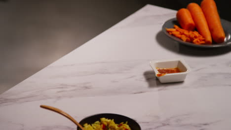 close up of woman at home in kitchen preparing healthy vegetarian or vegan meal of orzo pasta and roasted tomatoes 2