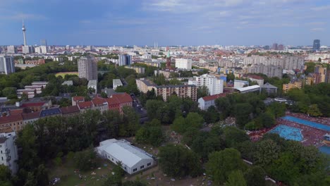lovely aerial top view flight tv tower, packed over crowded public swimming pool prinzenbad, city berlin germany summer day 2023