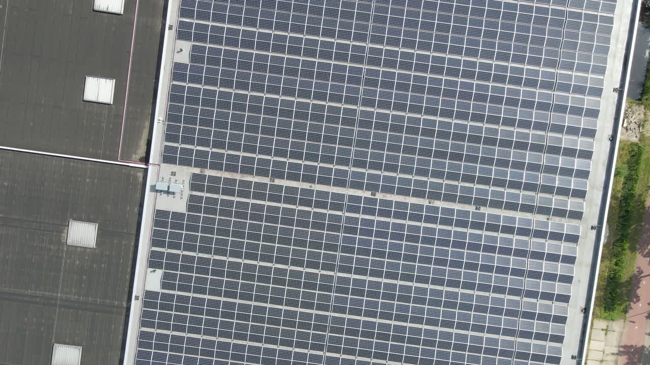 Vista aerea dall'alto di pannelli solari fotovoltaici su tetto piano - drone in atterraggio